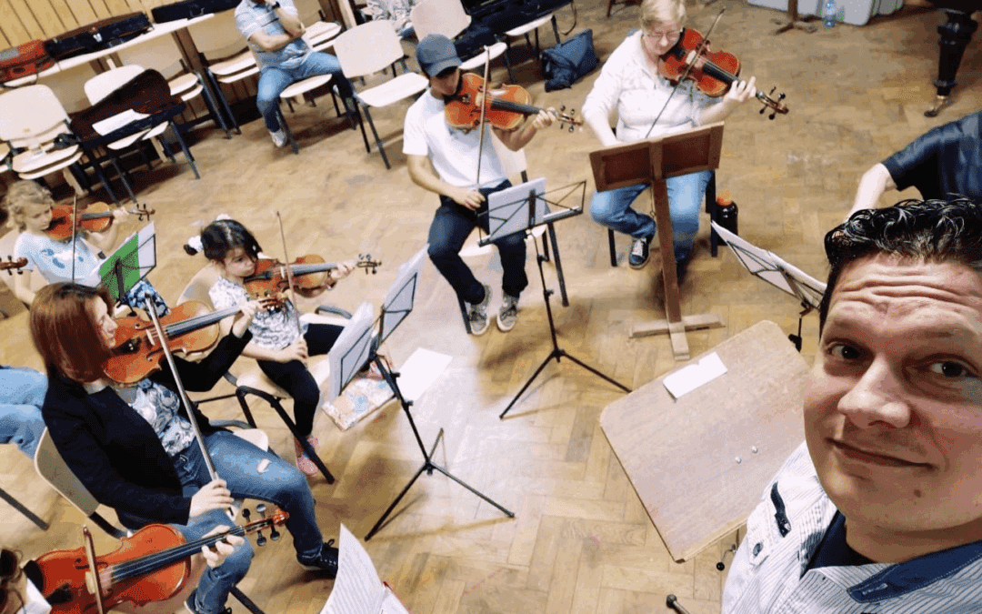 Youth orchestra practicing violin in a music classroom for El Sistema Austria program.